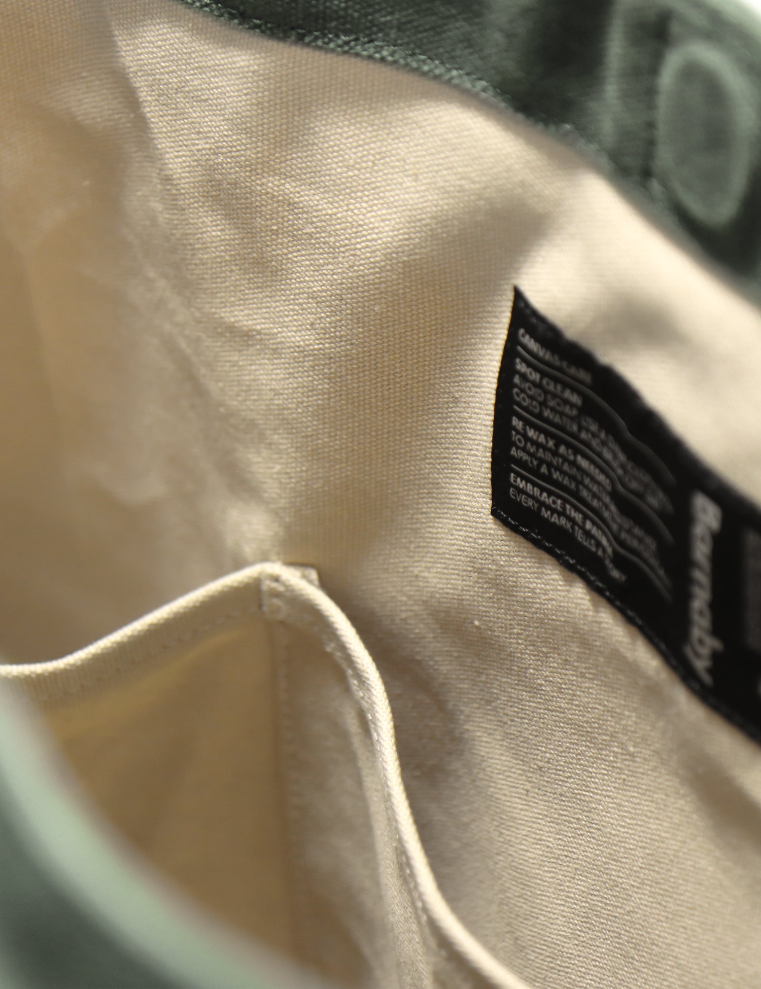 Close-up of a beige fabric with a black label on a green background