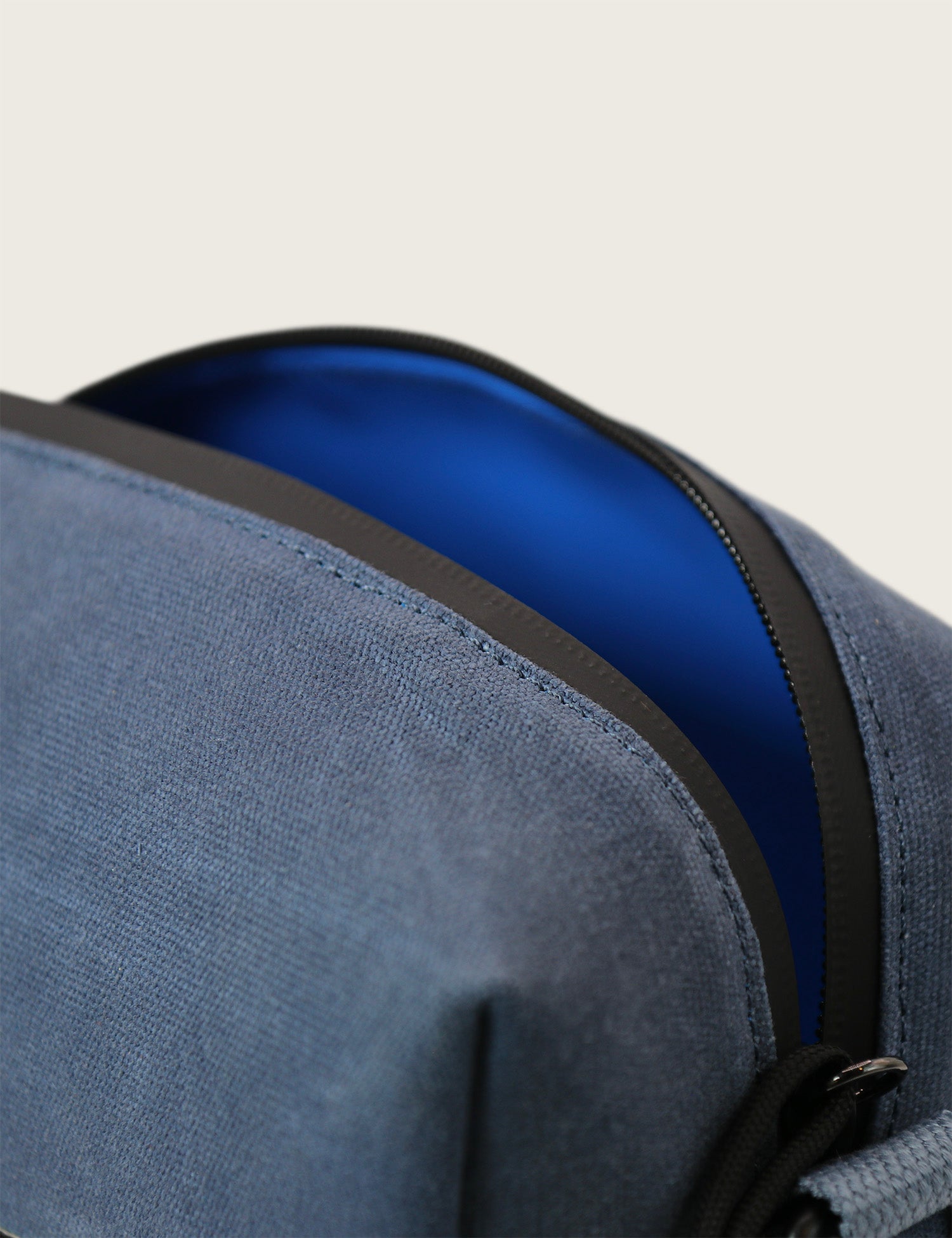 Close-up of a blue bag with a zipper on a light gray background