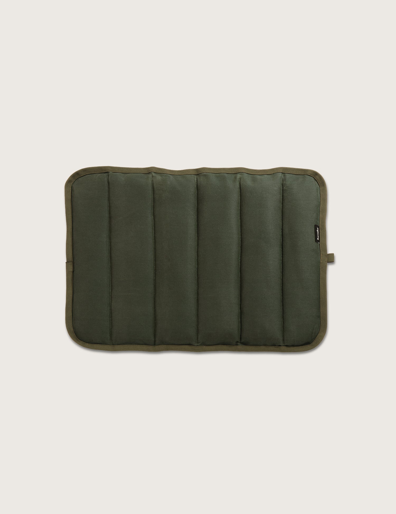 Green quilted dog mat top down view on a beige background