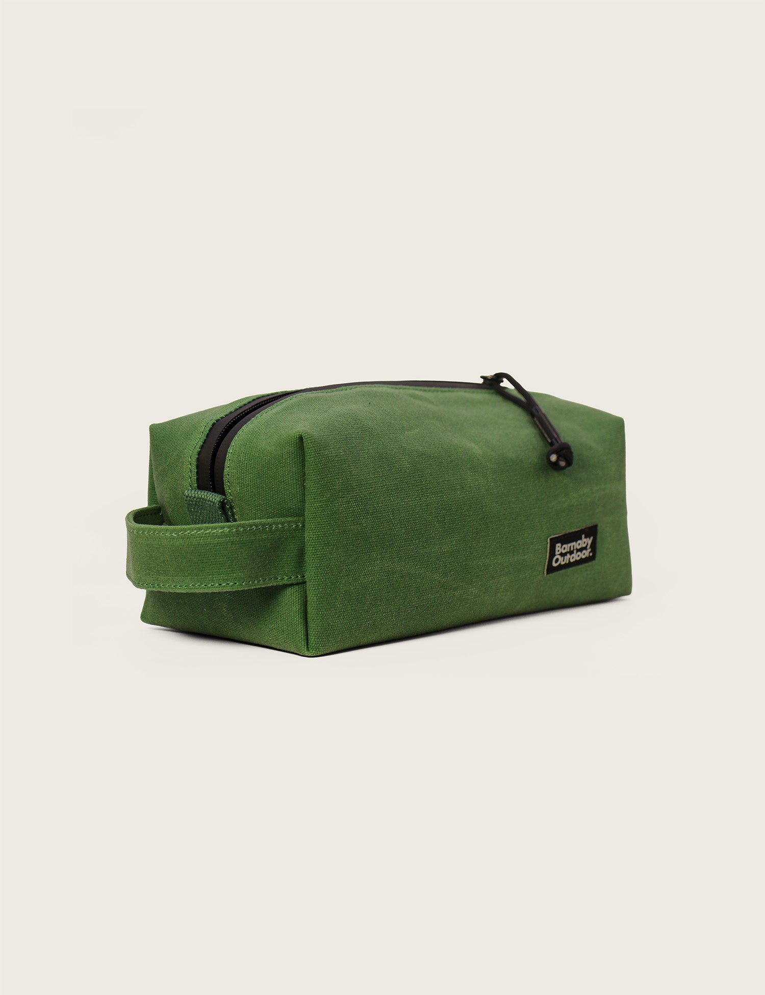 Green toiletry bag with a black zipper on a light beige background